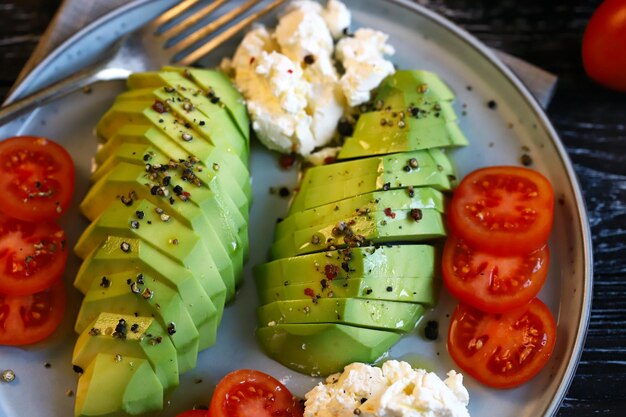 Tranches d'avocat avec fromage à la crème et tomates sur une assiette Macro de mise au point sélective Régime Keto