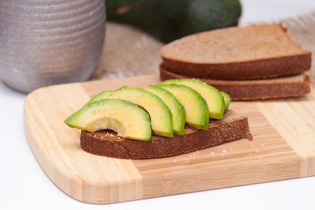 Tranches d&#39;avocat sur le pain noir grillé avec du sel. Collation saine.