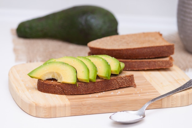 Tranches d&#39;avocat sur le pain noir grillé avec du sel. Collation saine.