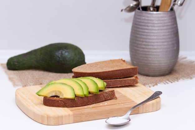 Tranches d&#39;avocat sur le pain noir grillé avec du sel. Collation saine.