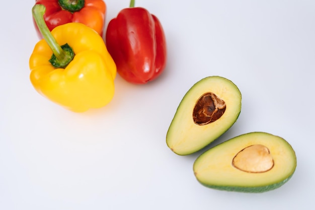 Tranches d'avocat et de poivrons sur fond blanc vue de dessus Fruits et légumes frais sur tableau blanc Concept d'une alimentation saine