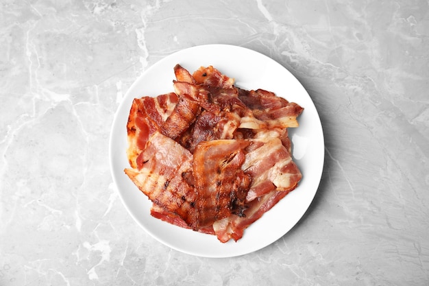 Tranches de bacon frit savoureux sur la vue de dessus de table en marbre clair