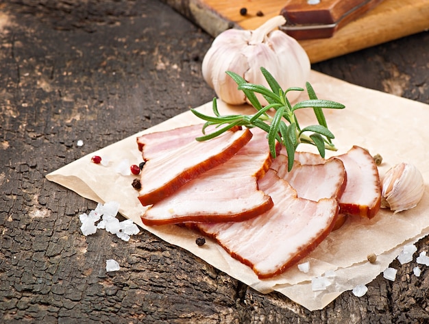 Tranches de bacon fumé sur la vieille table en bois