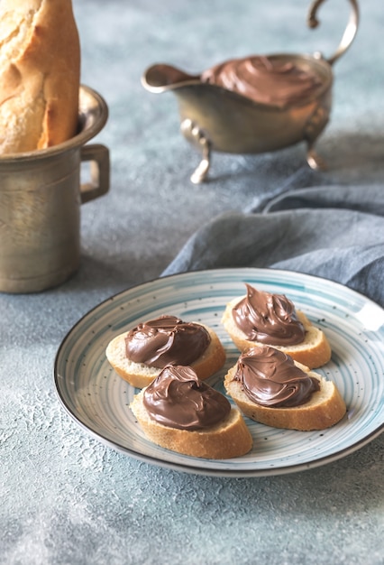 Tranches de baguette à la crème au chocolat sur la plaque