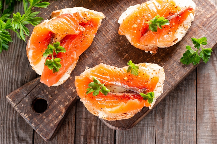 Photo tranches de baguette fraîche au beurre et saumon. apéritif de fruits de mer savoureux.
