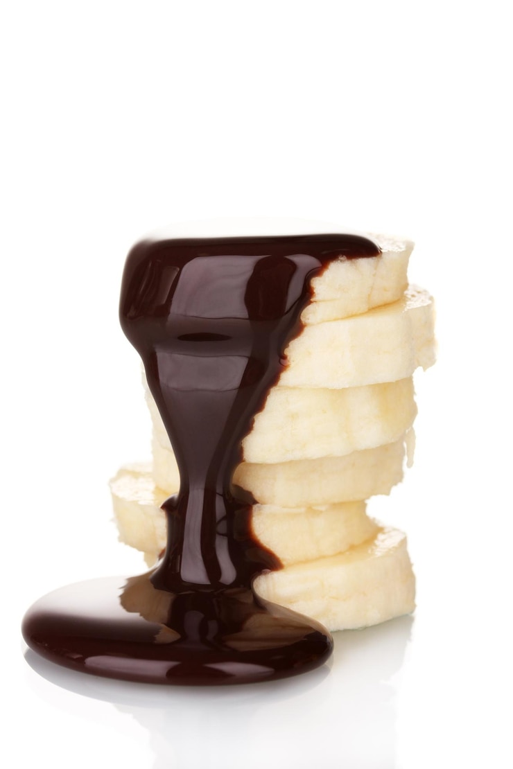 Photo tranches de banane mûre au chocolat isolé sur blanc