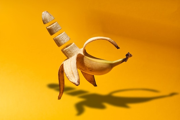 Photo des tranches de banane volant sur un fond jaune