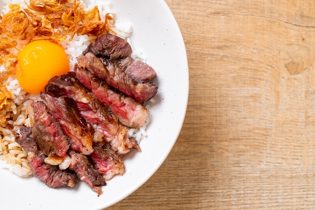 tranches de boeuf sur un bol de riz garni d'oeuf