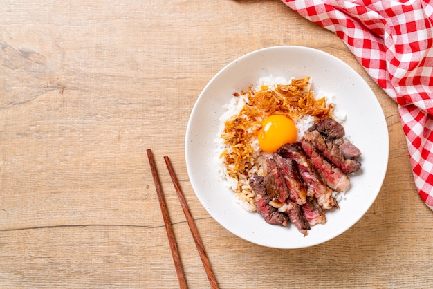 tranches de boeuf sur un bol de riz garni d'oeuf