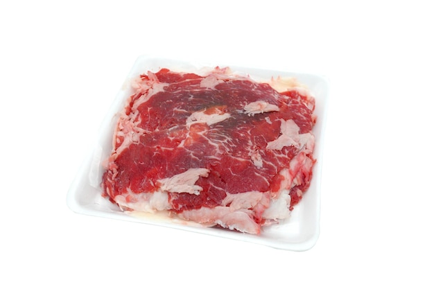 Tranches de boeuf cru en plastique blanc sur fond blanc