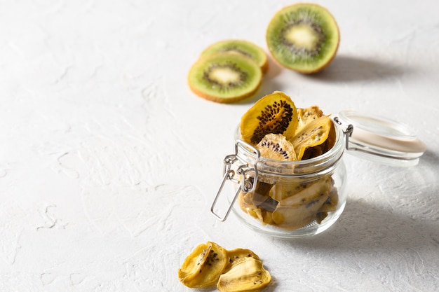 Tranches de chips de kiwi fruits végétaliens dans un bocal en verre