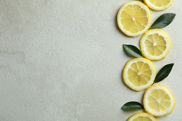 Tranches de citron et feuilles texturées sur blanc