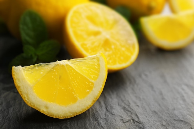 Tranches de citron frais avec des feuilles vertes sur la table libre