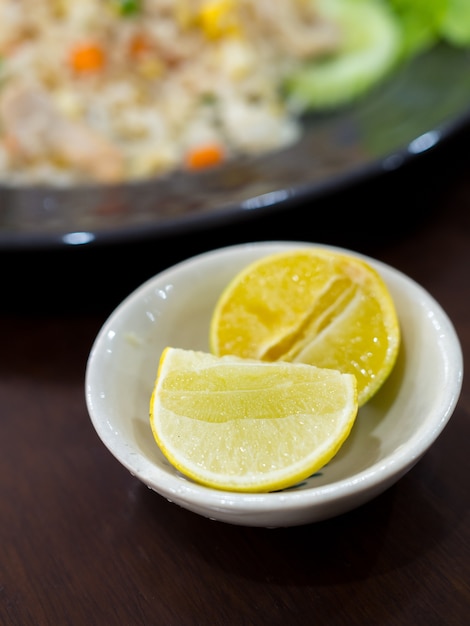 Tranches de citron vert dans la tasse sur la table en bois