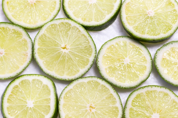 Tranches de citron vert sur fond blanc, une alimentation saine.