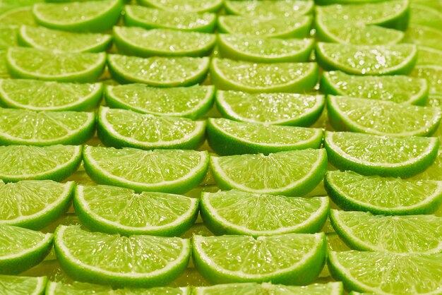 Tranches de citron vert frais en arrière-plan.