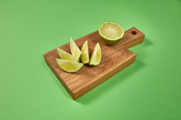 Tranches de citron vert frais bio sur une planche à découper en bois