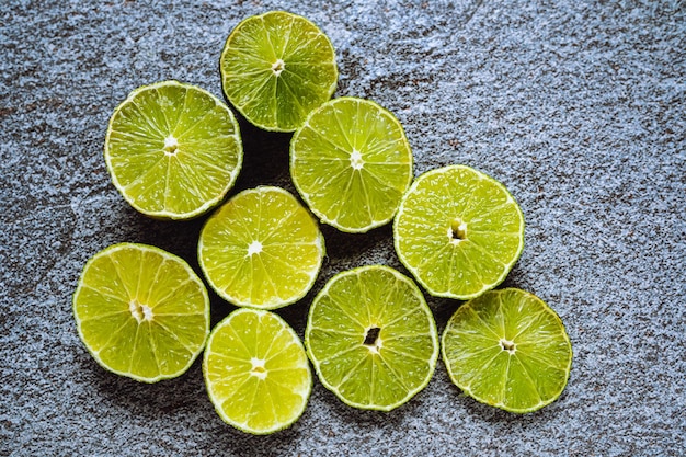 tranches de citron vert sur la texture de pierre grise