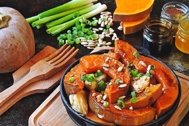 Tranches de citrouille au four dans une petite poêle en fonte. Recette pour rôtir la citrouille. Déjeuner végétalien chaud.