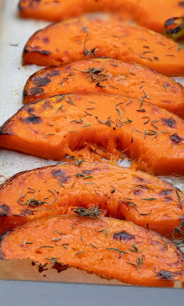 Tranches de citrouille grillées appétissantes sur une plaque à pâtisserie. À l'oignon.