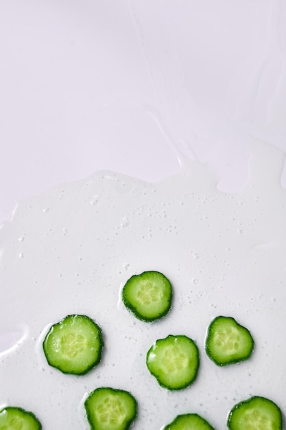 Tranches de concombre à plat avec gel sur fond blanc