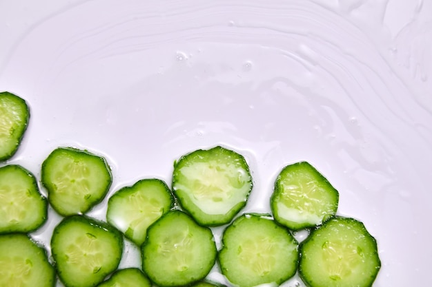 Tranches de concombre à plat avec gel sur fond blanc