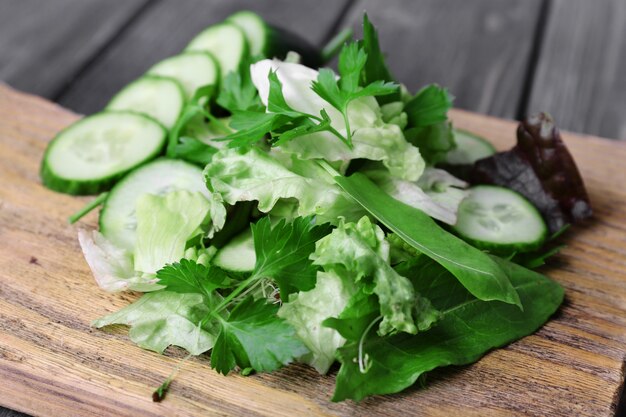 Tranches de concombre et de verdure sur une planche à découper et une surface de planches de bois