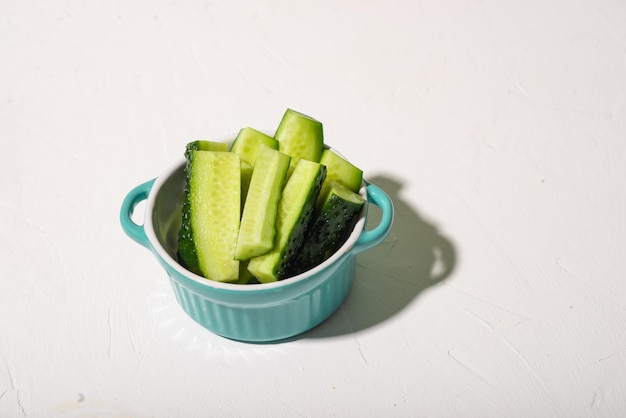 Tranches de concombres dans une assiette sur fond blanc