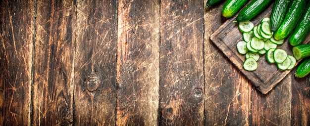 Tranches de concombres dans un bol. Sur table en bois.