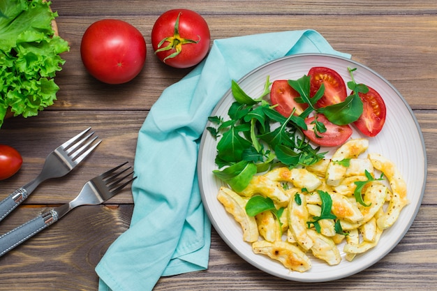 Tranches De Courgettes Appétissantes Cuites Au Four Avec Du Fromage Dans Une Assiette Avec Des Tomates Et De La Roquette Sur Une Table En Bois. Prêt à Manger. Fond