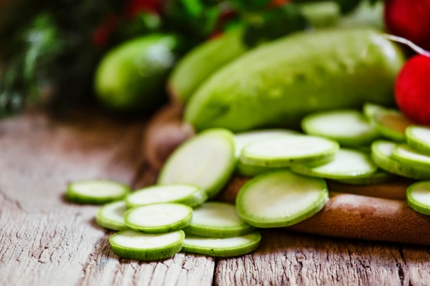 Tranches de courgettes rondes et radis frais fond de bois vintage mise au point sélective faible profondeur de champ