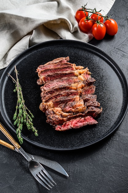 Tranches de faux-filet, bifteck de faux-filet sur une assiette avec un brin de thym. vue de dessus