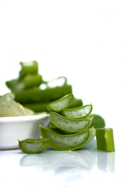 Des tranches de feuilles d'Aloe Vera et du gel d'Aloe Vera dans un bol. L'Aloe Vera est une phytothérapie très utile pour les soins de la peau et des cheveux.