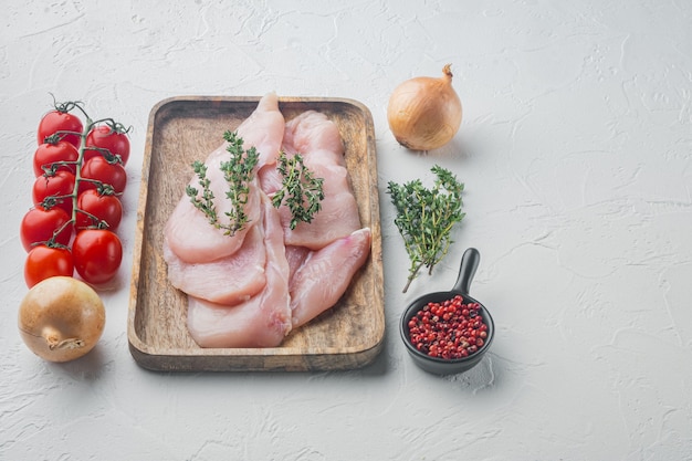 Tranches de filets de viande de poulet cru, sur fond blanc avec espace de copie pour le texte