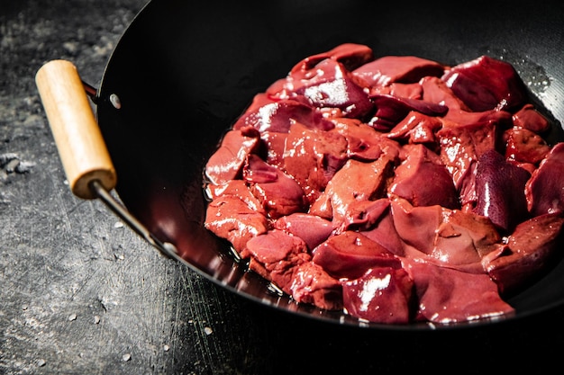 Tranches de foie cru dans une casserole