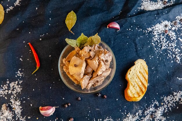 tranches de foie de poisson de grande petite morue dans des bocaux en verre avec sauce et couvercles en métal, debout et allongé,