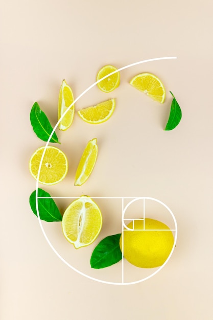 Photo tranches fraîches de fruits citron vert citron jaune avec feuille verte et glaçon disposés sur un fond pastel sous forme de nombre d'or