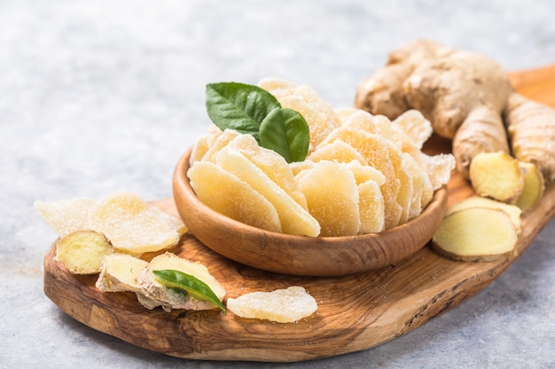 Tranches de fruits secs au gingembre et racine de gingembre sur une table en pierre