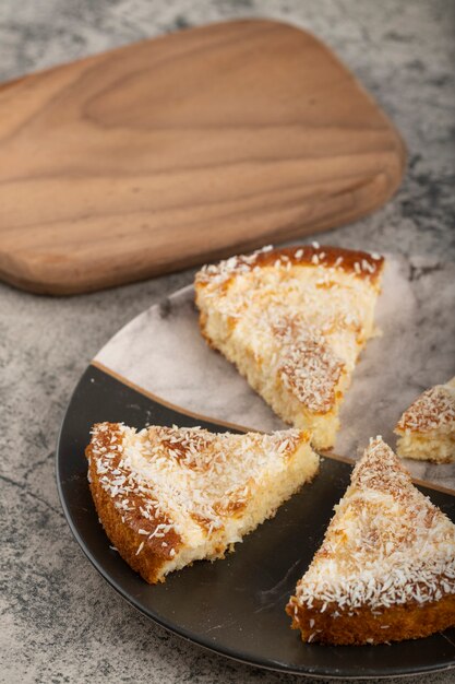 Tranches de gâteau dessert avec copeaux de noix de coco placés sur une belle assiette.