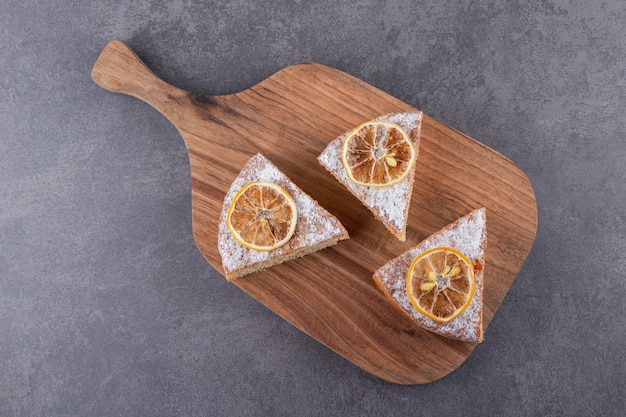 Tranches de gâteau maison aux citrons placés sur une planche de bois.