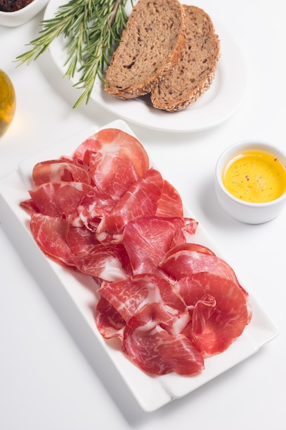 Tranches italiennes de coppa, capocollo, capicollo ou jambon cru au romarin. Nourriture crue.