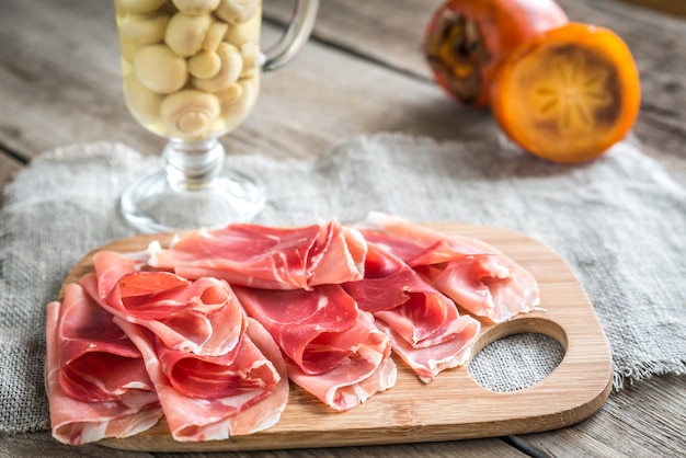 Tranches de jambon sur la planche de bois