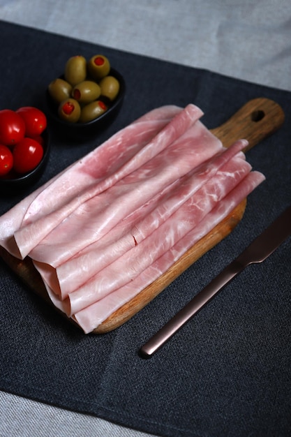 Tranches de jambon de porc sur une planche de bois