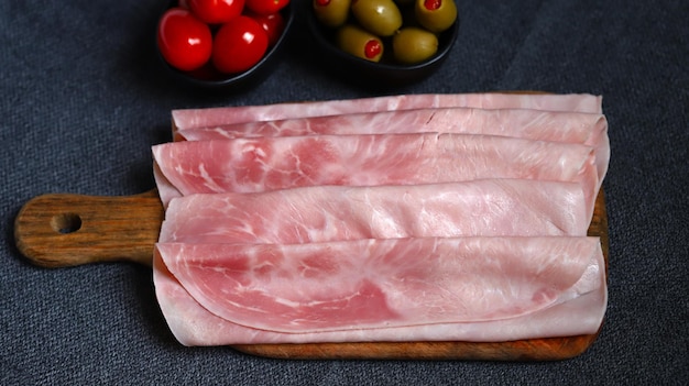 Tranches de jambon de porc sur une planche de bois