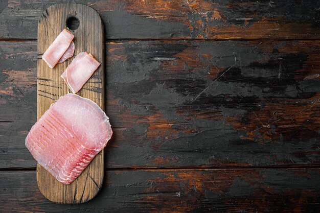 Tranches de jeu de prosciutto, sur le vieux fond de table en bois sombre, vue de dessus à plat, avec copie espace pour le texte