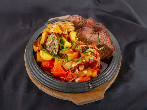 Photo des tranches juteuses de filet de bœuf cuit avec des légumes sont servies. mise au point sélective, gros plan. plis de tissu