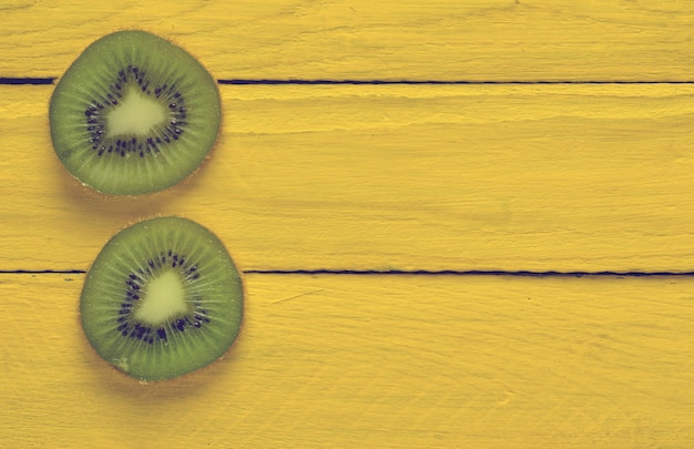 Tranches de kiwi sur une surface en bois jaune