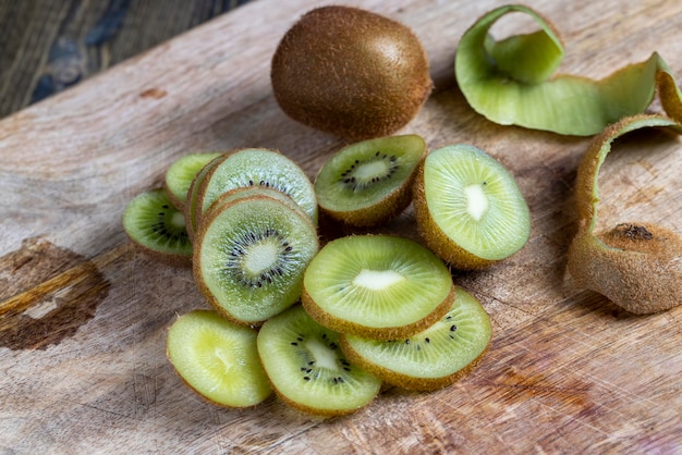 Tranches de kiwi vert mûr sur une planche à découper kiwis lavés et coupés en morceaux