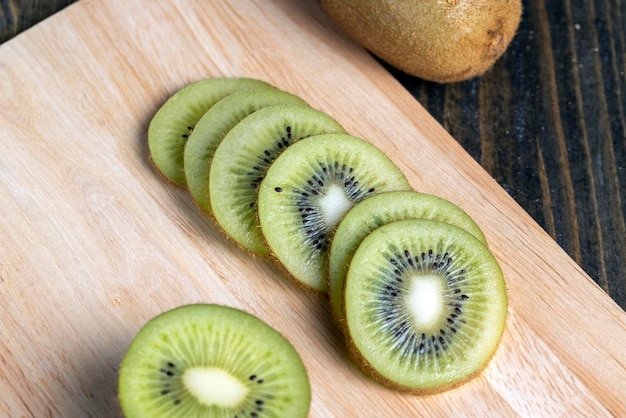 Tranches de kiwi vert sur une planche de bois