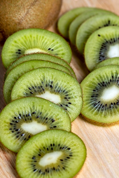 Tranches de kiwi vert sur une planche de bois